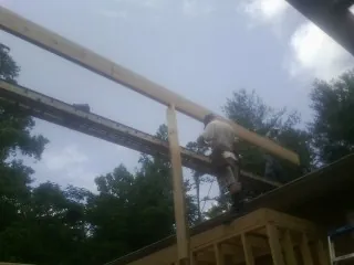 Carpenter setting a ridge beam over a new addition frame — Ice Dam Removal by Roofing Brothers in Santa Clarita
