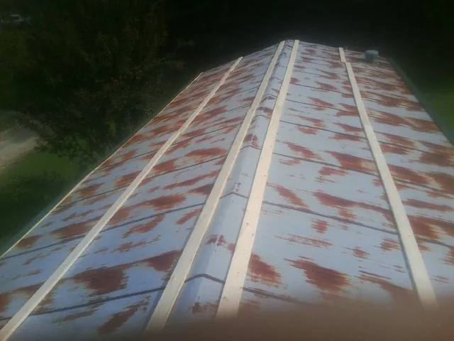 Rusted metal roof panels with new wood purlins before replacement — Storm Damage Roof Repair in Santa Clarita by Roofing Brothers