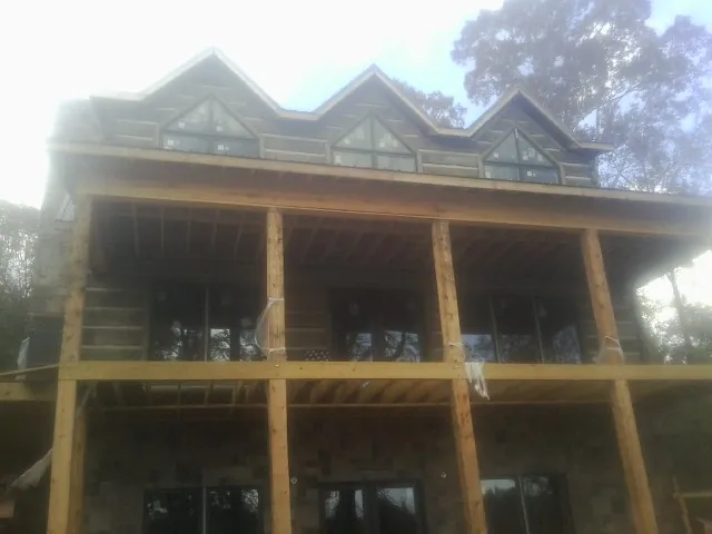Dormers and porch framing on a large log home under construction — Roof Coating work by our crew in Santa Clarita
