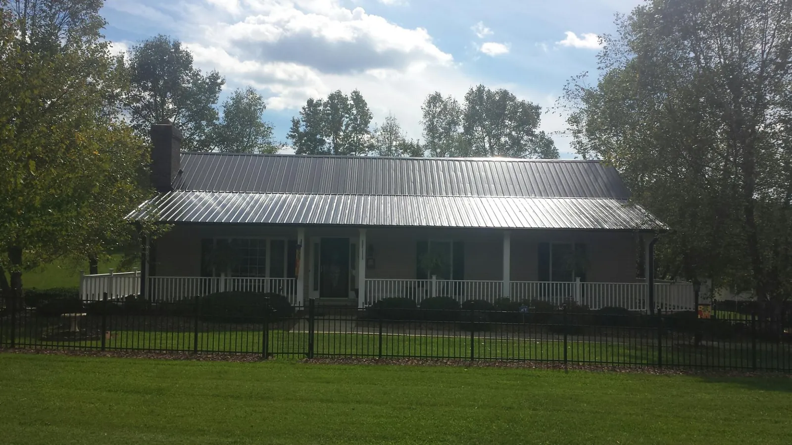 Gray metal roof on a brick ranch with a full width front porch — Gutter Guard Installation work by our crew in Santa Clarita